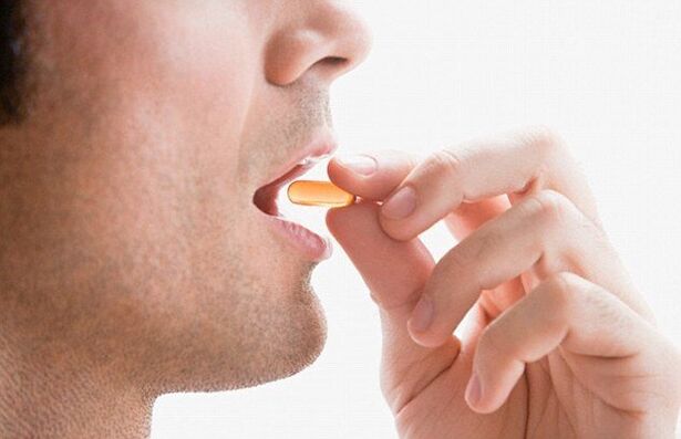 Vīrietis lieto vitamīnu kompleksu, lai uzturētu potenci